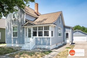 A two-story house with a front porch, a chimney, and a garage. - Holland Hideaway (Holland)