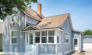 A two-story house with a front porch, a chimney, and a garage.
