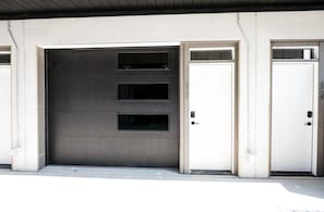 Garage entrance with a large door and a separate entrance to the right.