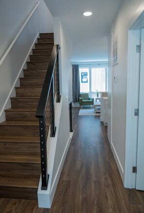 Stairs lead to an upper level, with a door and window offering a view.