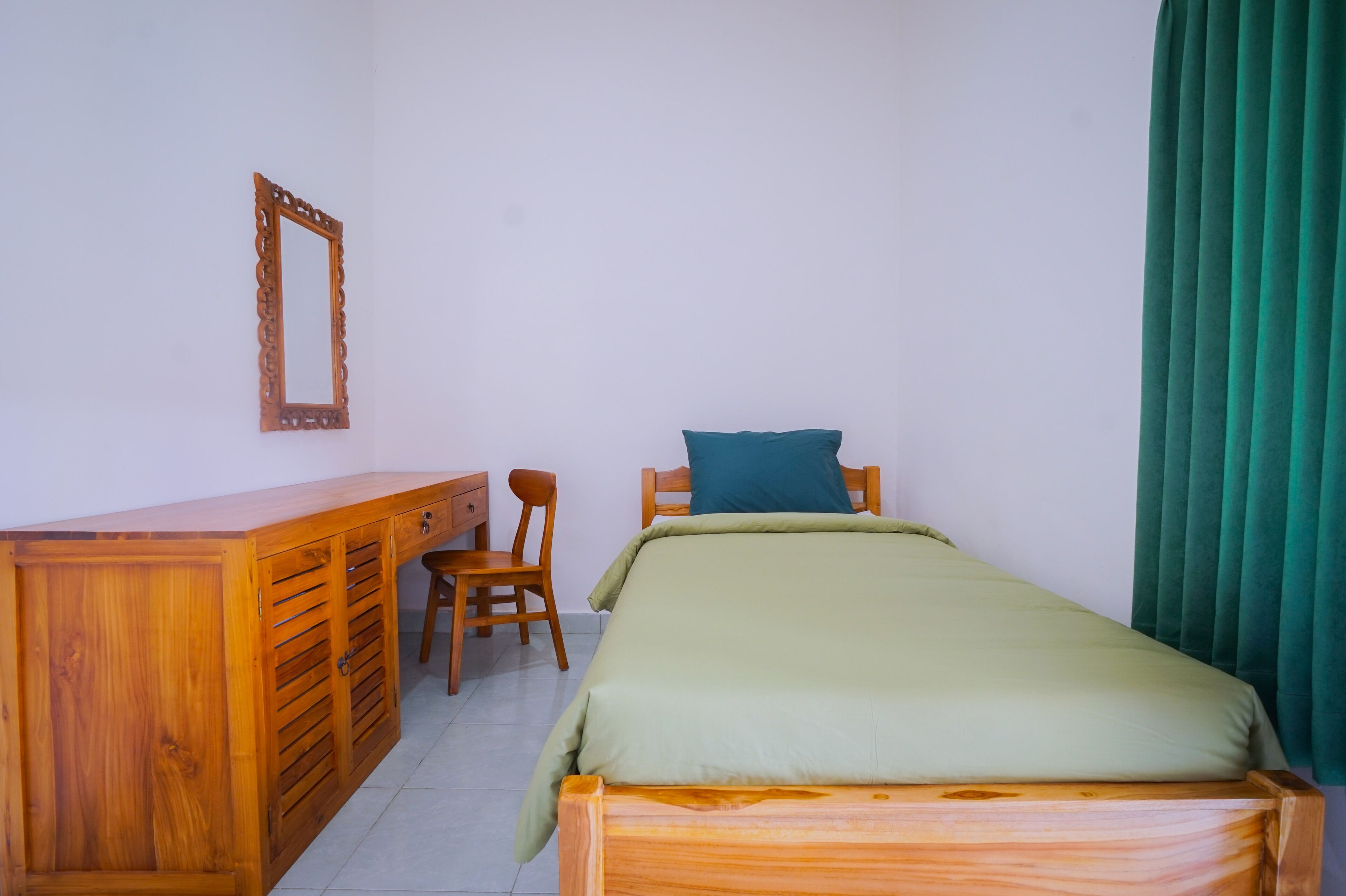 A room with a wooden bed, a desk, and a chair.