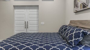 Un dormitorio con una cama, un armario y un cuadro en la pared.