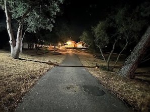 A pathway leading to a house at night with lights illuminating the area. - Picayune Retreat: Spa/EV/Play-structure/Pet-loving/Games and more'' (Coarsegold)