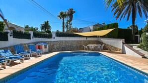 Una piscina amb gandules i una paret de pedra.