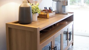 Eine moderne Küche mit einer Holzauszug, einem großen Spiegel, einer Lampe und einer Kaffeemaschine.