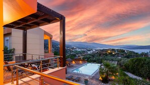 A modern outdoor pool area with a view of a cityscape and mountains. - Villa Glan Y Mor in Agios Nikolaos (Agios Nikolaos)