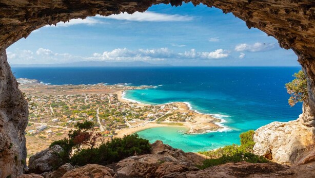 A coastal town viewed through a cave opening, with clear blue sea and distant land. - Villa Glan Y Mor in Agios Nikolaos (Agios Nikolaos)