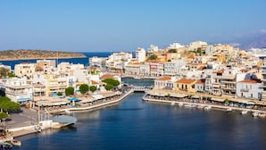 A coastal town with a central canal, buildings with balconies, and a clear view of the sea. - Villa Elounda Plaka in Plaka (Agios Nikolaos)