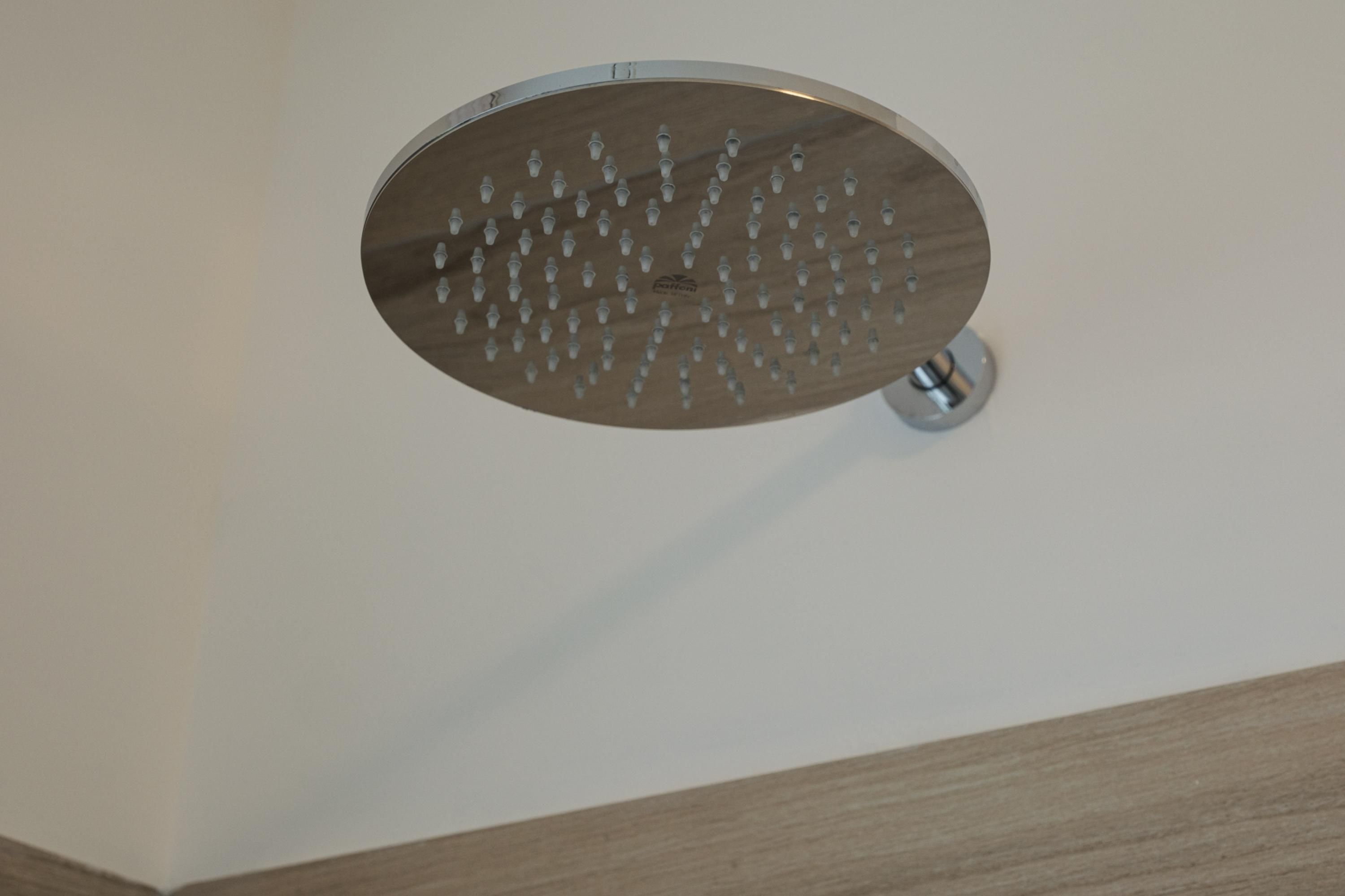 Un cabezal de ducha con múltiples boquillas montado en una pared.