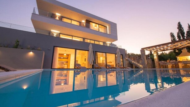 Un bâtiment moderne à deux étages avec une piscine à l’avant.