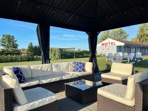 An outdoor seating area with wicker furniture and a covered section. - Best Motel Bowling Green (Bowling Green)