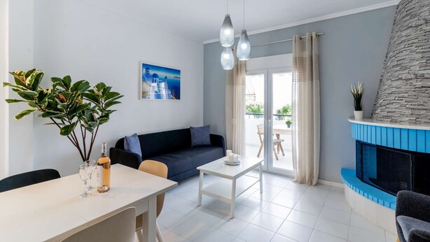 En moderne stue med sofa, spisebord og pejs.