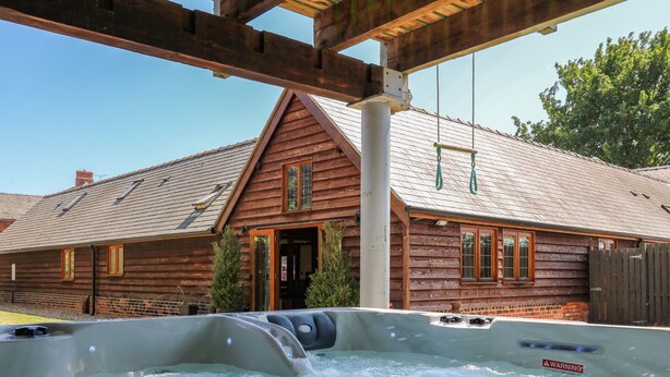 A wooden cabin with a hot tub in front. - Awelfan (Newtown)