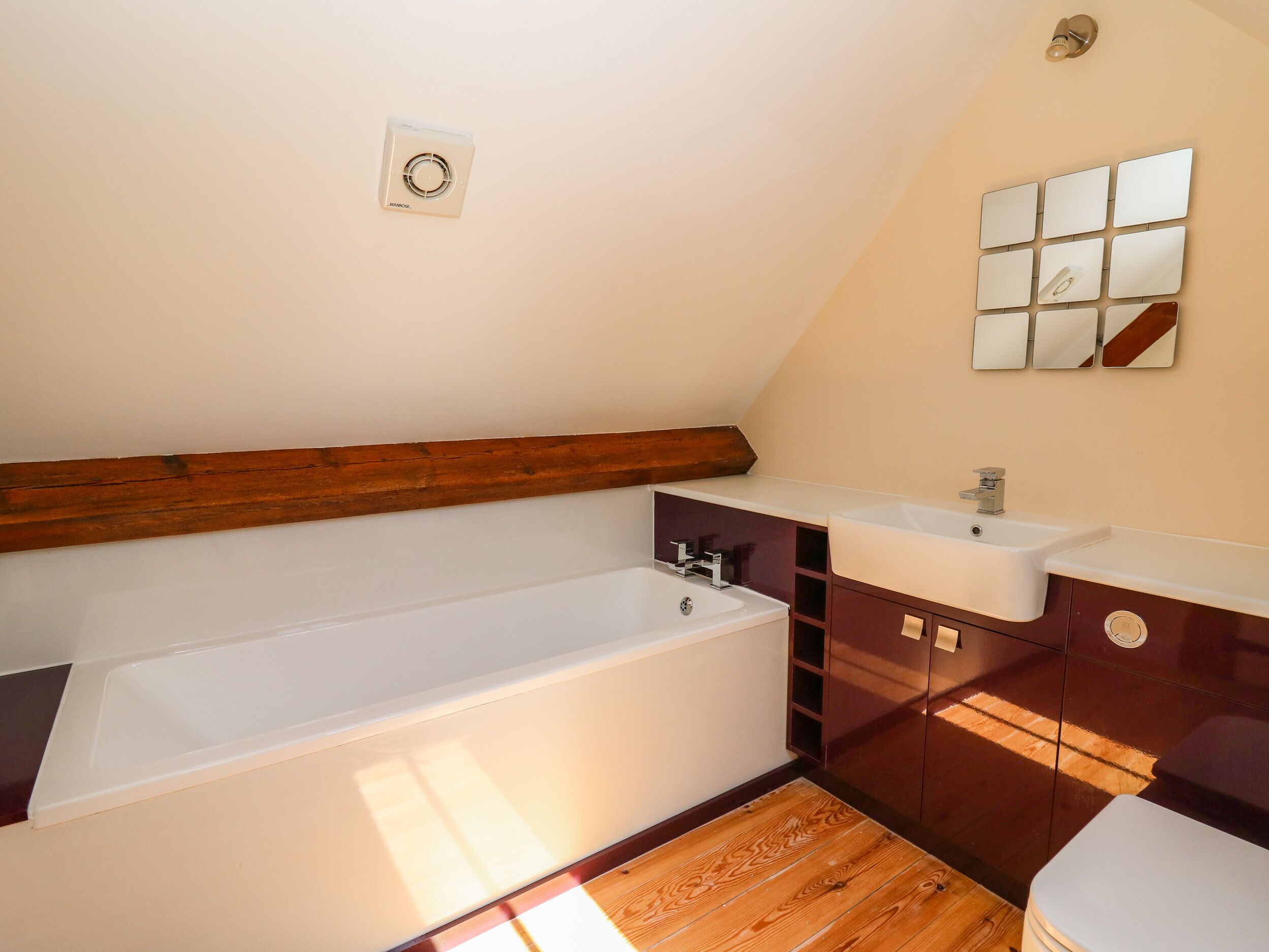 A modern bathroom with a bathtub, vanity, and a mirror wall.