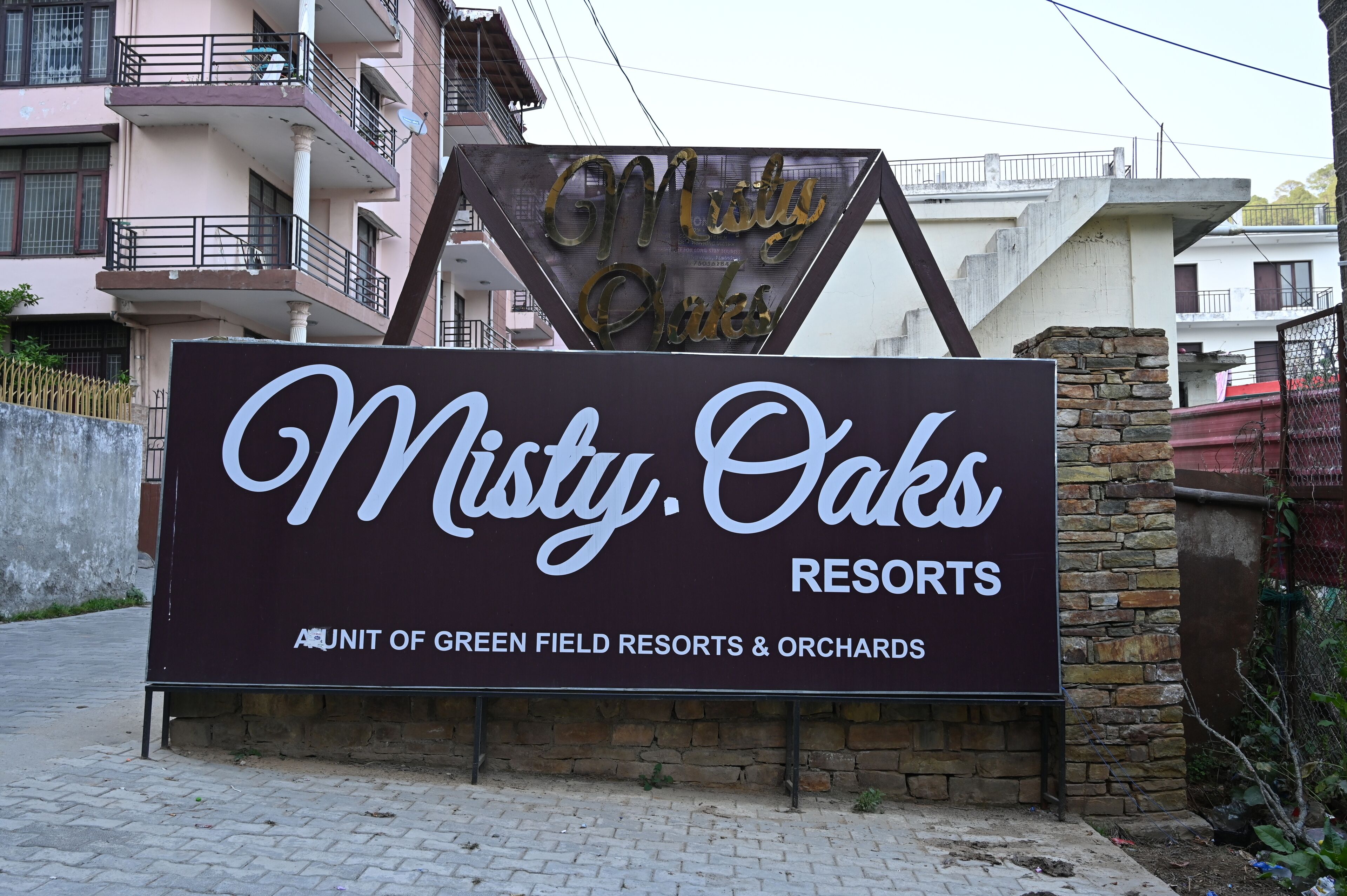 Placa para Misty Oaks Resorts, indicando que faz parte dos Green Field Resorts & Orchards.