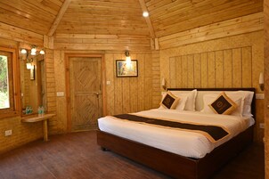 A wooden-paneled bedroom with a large bed, a bedside table, and a mirror.