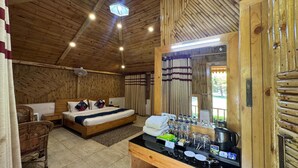 A wooden cabin-style room with a bed, a small table with amenities, and a large mirror. - Foxoso Misty Oaks Resort (Nainital)