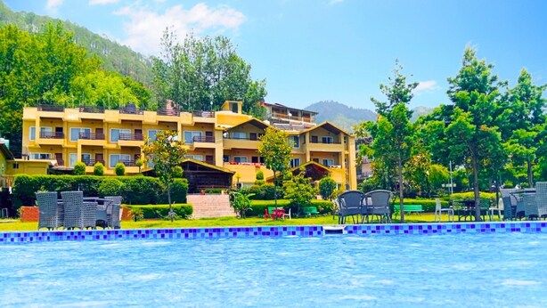 A hotel with multiple floors, a swimming pool, and greenery. - Foxoso Misty Oaks Resort (Nainital)