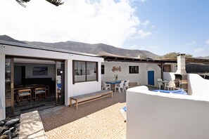 A modern house with a patio, a dining area, and a barbecue setup.