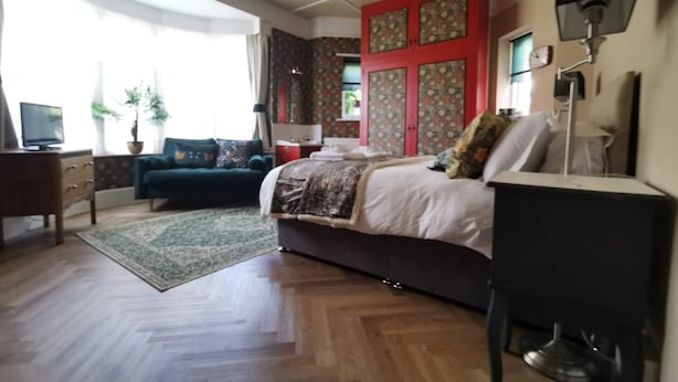 A bedroom with a bed, a desk, a chair, a TV, and a window with curtains. - Ground floor Spacious double bed room, free parking close to seafront. (Bexhill)