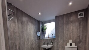 A modern bathroom with a shower, toilet, and sink. - Ground floor Spacious double bed room, free parking close to seafront. (Bexhill)