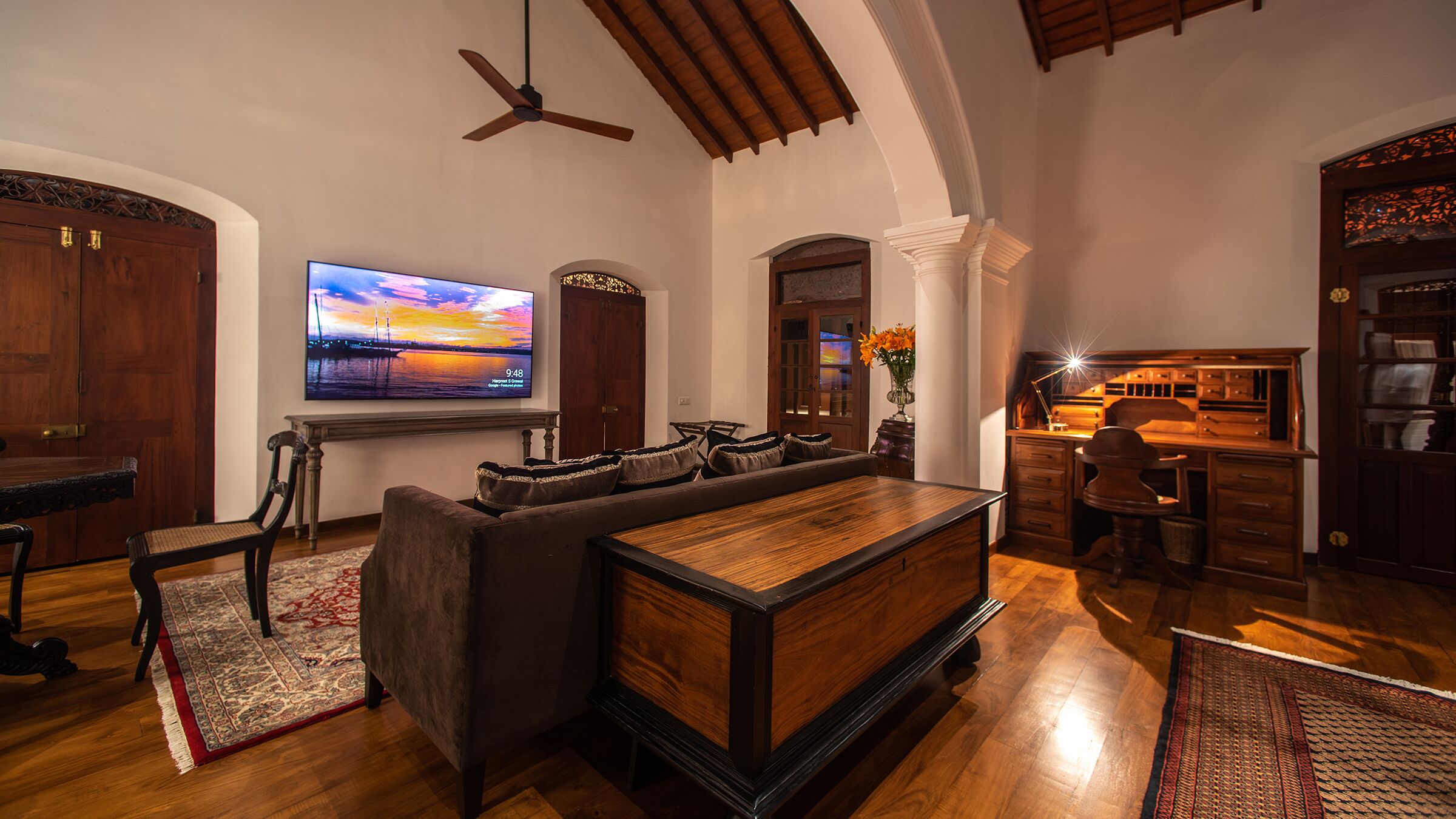A spacious living room with a large flat-screen TV, a wooden bar area, and a cozy seating arrangement.
