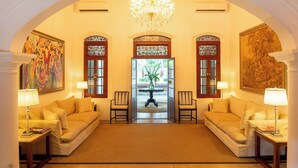 A spacious lobby with two sofas, a chandelier, and artwork on the walls. - maya tangalle (Tangalle)