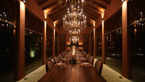A long dining table set for a meal with a chandelier above. - maya tangalle (Tangalle)