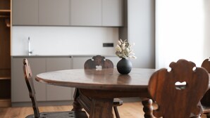 Een eettafel met stoelen, een vaas met bloemen en een hanglamp.