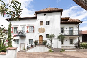 A two-story building with a balcony, a staircase, and a door.