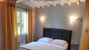 Una camera da letto con un letto, tende, una finestra e luci a parete.