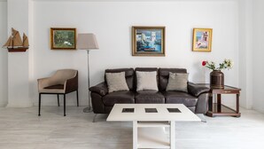 A modern living room with a leather sofa, a white coffee table, and a side table with a vase.