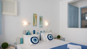 A bedroom with a bed, pillows, wall art, a nightstand, and a window.