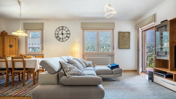Un salon moderne avec un canapé, une table à manger et une grande fenêtre.