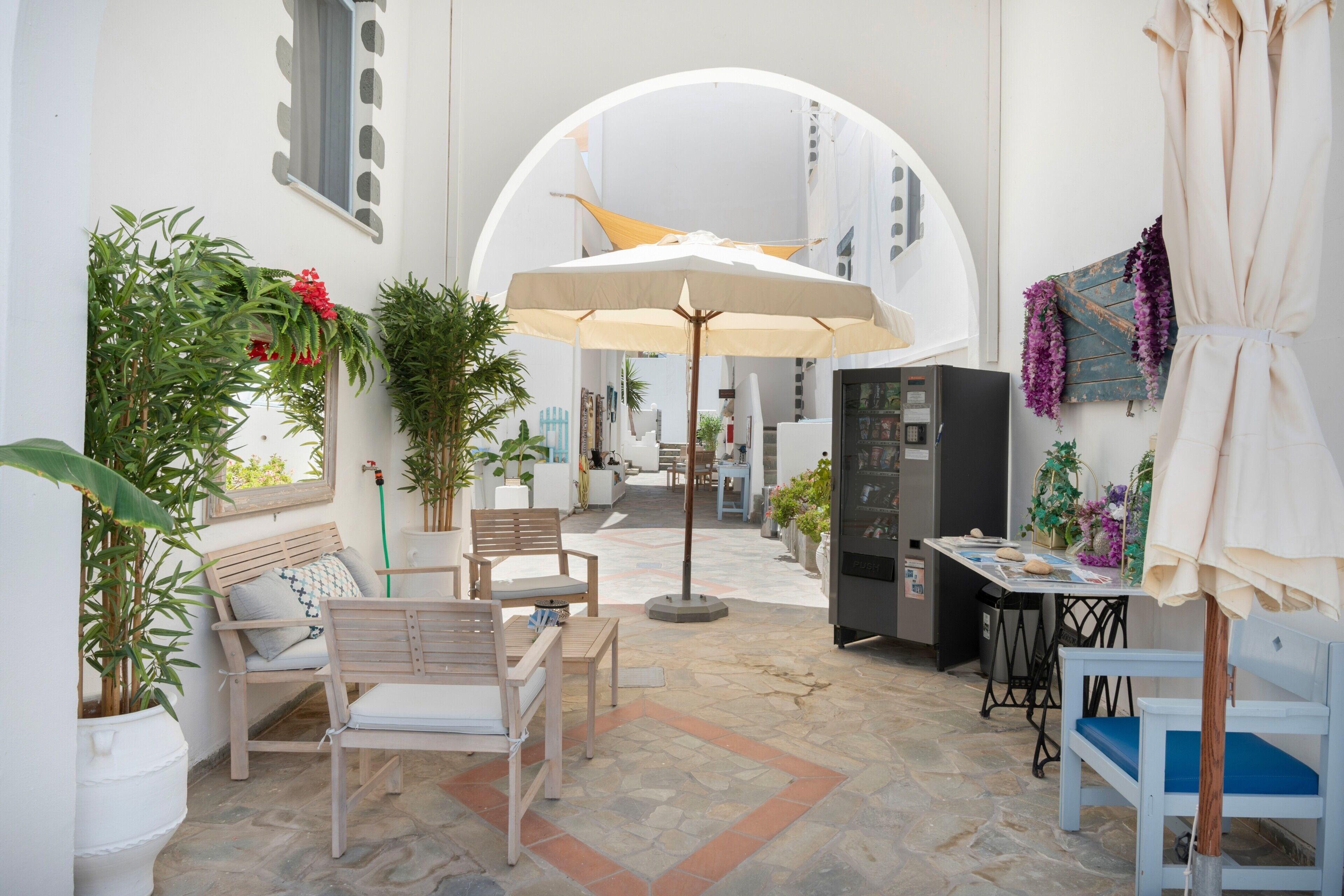 Un patio intérieur accueillant, avec des sièges, une table et un grand parasol.