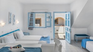 A hotel room with two beds, a small table, a chair, and a view of the outside.