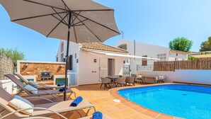 A swimming pool with lounge chairs and a table, a barbecue area, and a covered patio. - Holiday Home 'Ca Na Luisa' with Sea View, Wi-Fi and Air Conditioning (Palmanova)