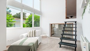 A modern bedroom with a bed, a small table, a shelving unit, and a large window with a view of greenery. - Holiday Home 'Ca Na Luisa' with Sea View, Wi-Fi and Air Conditioning (Palmanova)