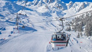 A ski lift with a cable car labeled 'COURCHEVEL' ascending a snowy mountain slope. - Comfortable 2 Rooms, Ski-in/Ski-out, 4 Pers. Near Shops (La Tania)