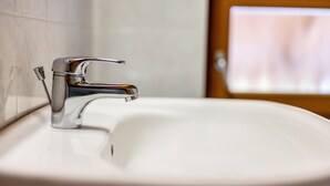 Ein Waschbecken mit einem Chromarmaturen und einer weißen Schüssel.