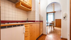 Une cuisine avec des meubles en bois, un réfrigérateur blanc et un pare-feu en carreaux.