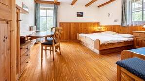 Une chambre à coucher en bois, avec un lit, un bureau et une chaise.