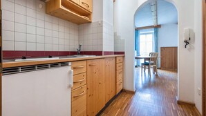 Una cocina con armarios de madera, un refrigerador blanco y salpicadero de azulejos.