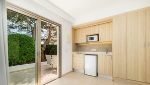 Una cocina moderna con microondas, refrigerador y armarios de madera.