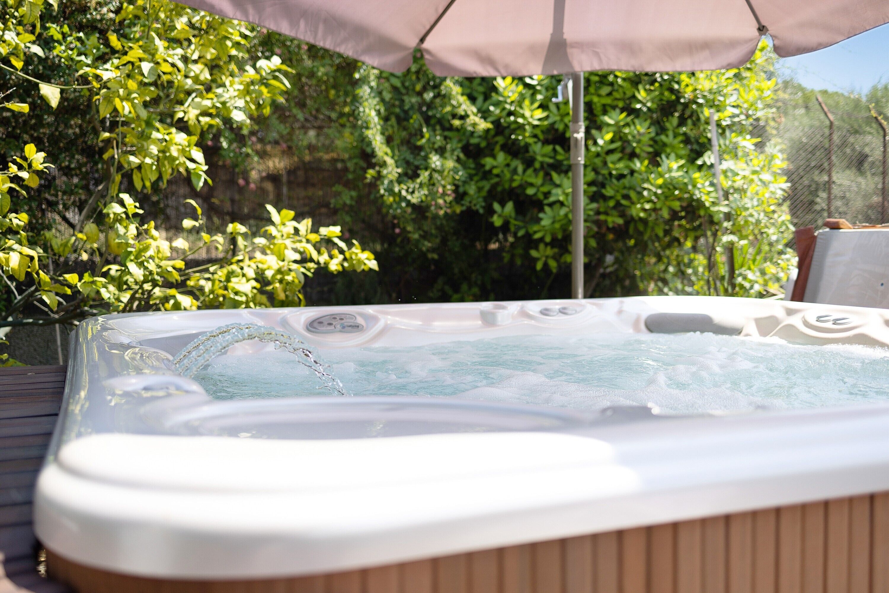 A hot tub with a wooden deck and a canopy.