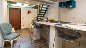 A modern kitchen with a marble countertop, a built-in stove, and a wooden door. - Holiday Home "Sikelia Relais" with Mountain View & Wi-Fi (Linguaglossa)