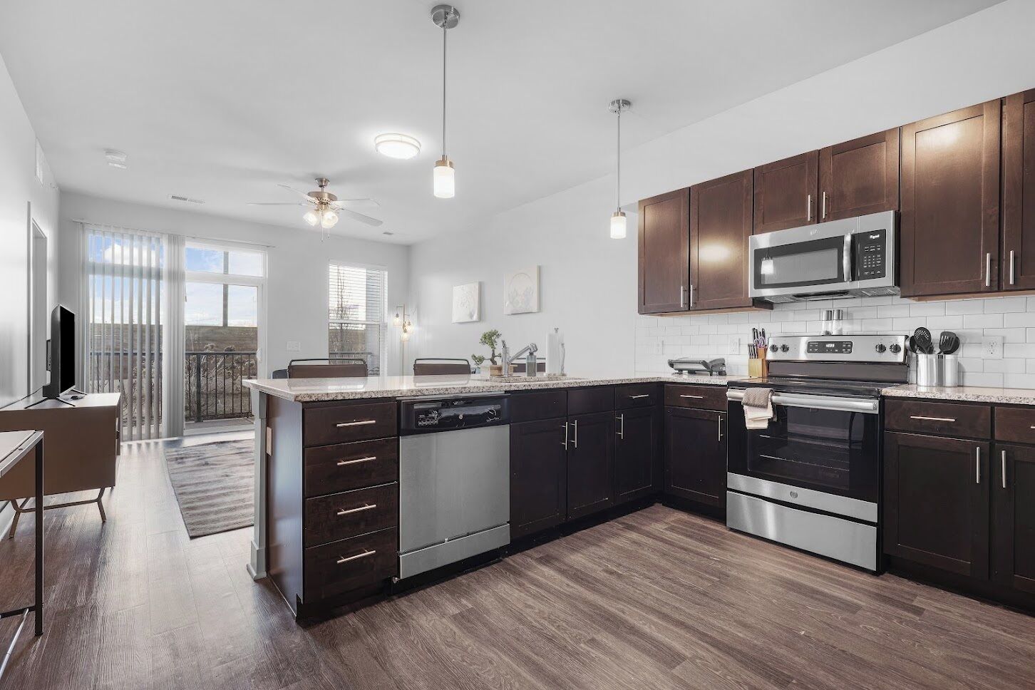 Una cocina moderna con armarios de madera oscura, electrodomésticos de acero inoxidable y una isla grande.