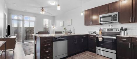 Una cocina moderna con armarios de madera oscura, electrodomésticos de acero inoxidable y una isla grande.