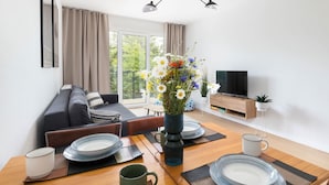 Una sala de estar moderna con sofá, mesa de comedor y televisor.