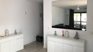 Un baño limpio y moderno con dos armarios blancos, un espejo grande y un ventilador de techo.